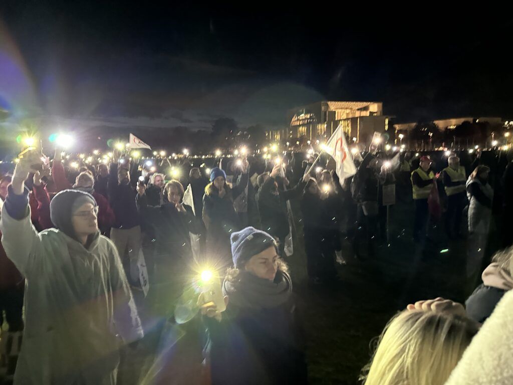 Menschen halten Nachts ihre Handys mit Licht hoch.