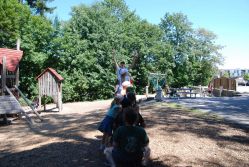 Kinder spielen gemeinsam auf einem großen Spielgerät auf dem Spielplatz.